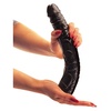 A jelentősen erezett nagy fekete dildó méretének szemléltetése a kézben.