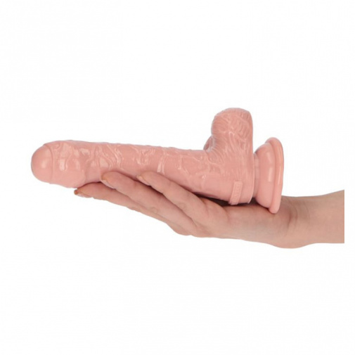 A pénisz alakú, teszszínű, valósághű dildó mérete közelről.